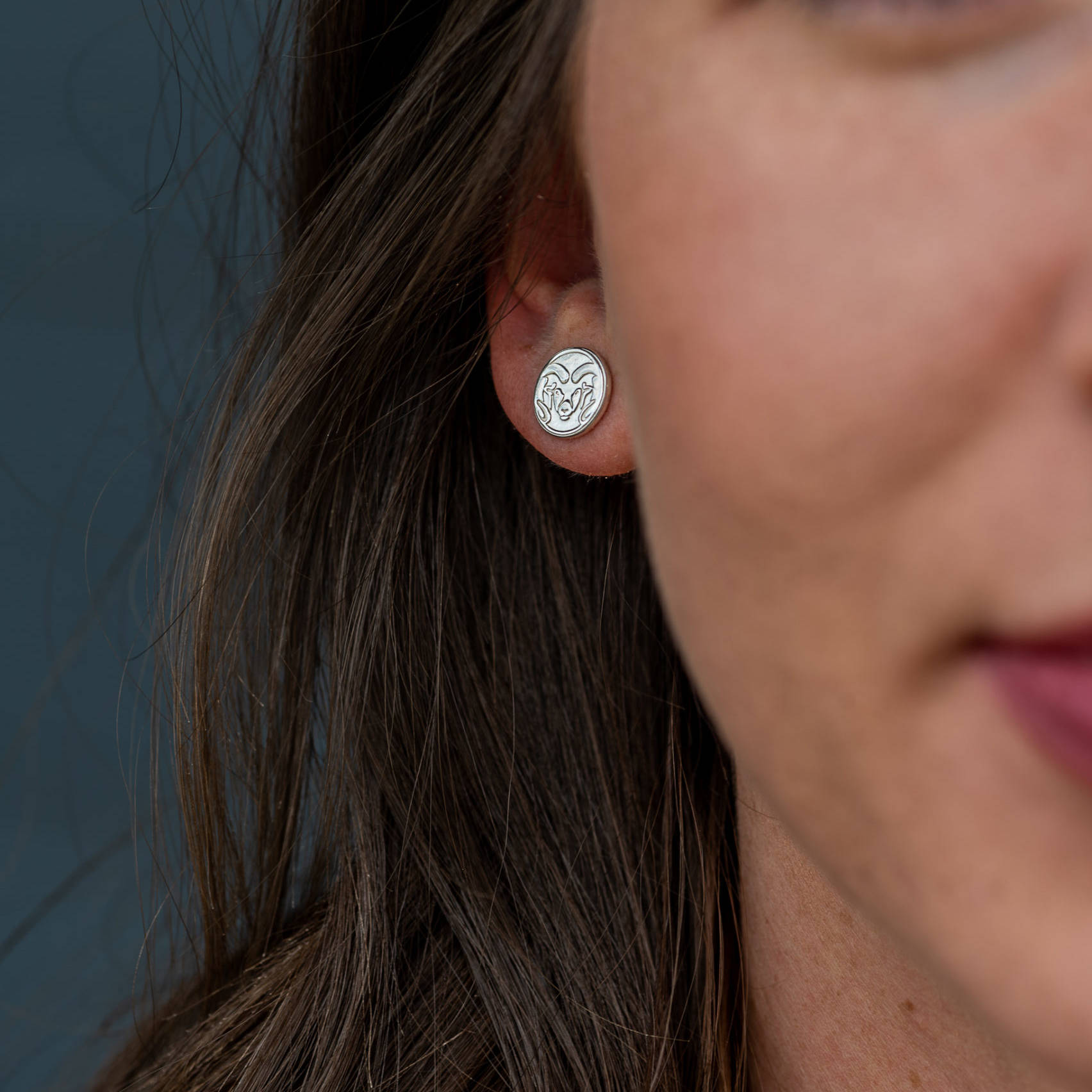 csu silver earring on womans ear
